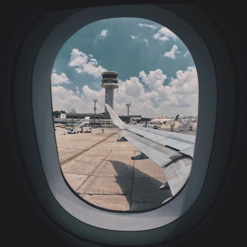 Photo looking out of an airplane on the tarmac with a view of the wing